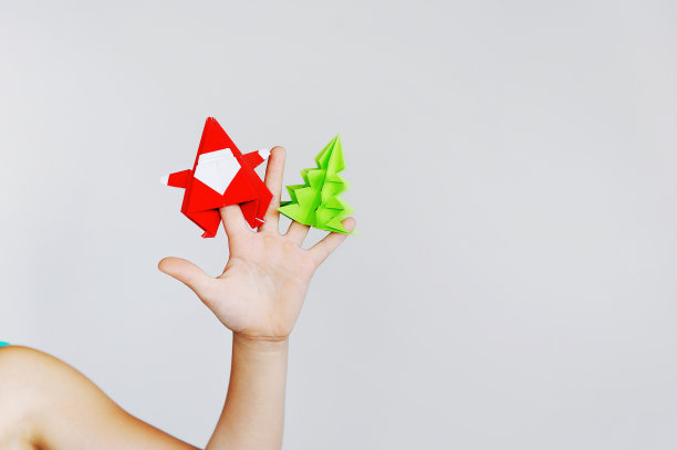 这个女孩在做圣诞折纸。圣诞老人,杉树。图片下载