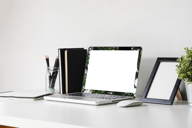侧视图模拟笔记本电脑在白色桌子上与办公用品。图片下载