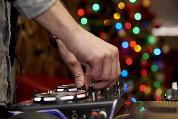 手中的DJ在遥控器上，身后的五颜六色的一边图片下载
