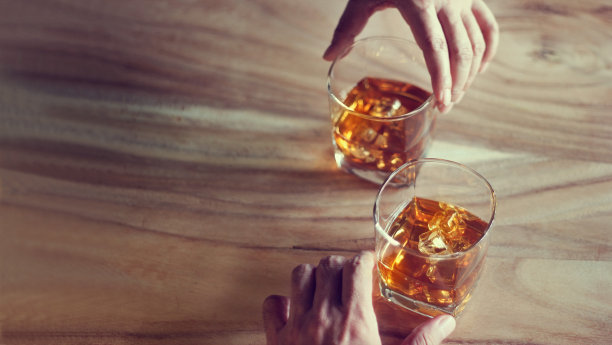 双手威士忌波旁威士忌在两个杯子在一个垃圾木背景图片下载