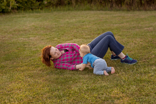 一岁的宝宝和妈妈在草地上玩。图片下载