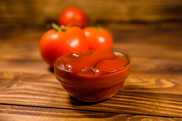 木桌上放着成熟的西红柿和番茄酱图片下载