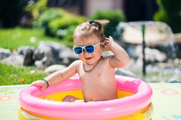 可爱的蹒跚学步的男孩在充气游泳池图片下载
