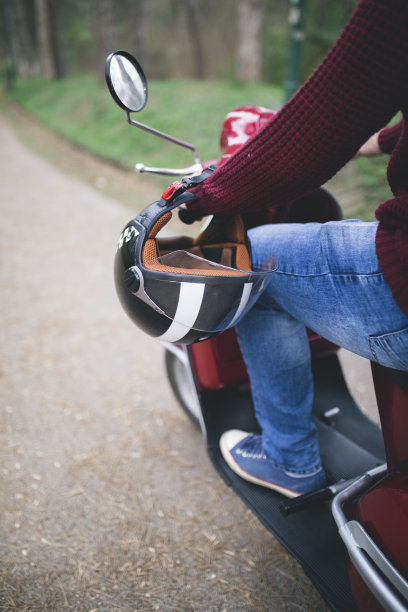 戴着头盔坐在老式摩托车上的年轻嬉皮士。图片下载