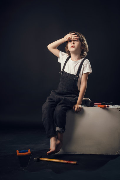 在工作室里，一个以白色为背景的孩子情绪激动地对着相机摆姿势图片下载