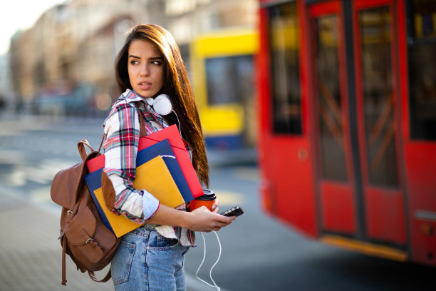 时髦迷人的女孩在等公共汽车图片下载
