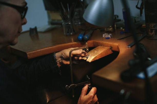 女珠宝工匠用带锯切割金属图片下载