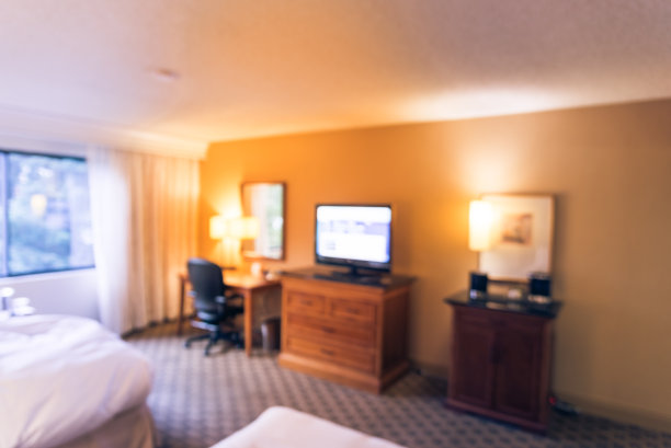 模糊背景的双人床酒店房间与平板电视在美国图片下载