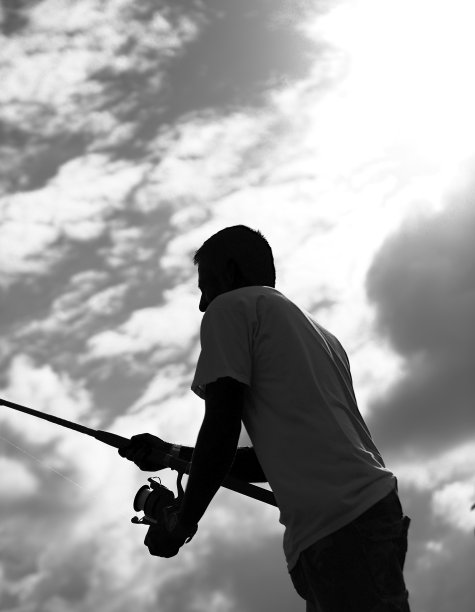 一个年轻人在湖边钓鱼图片下载