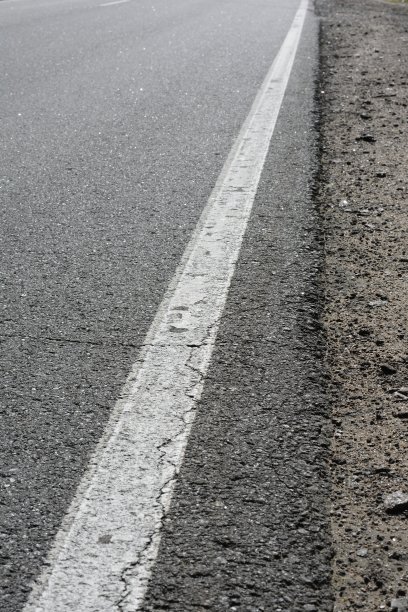 公路上有开裂的沥青，一条连续的狭长公路和一段路边图片下载