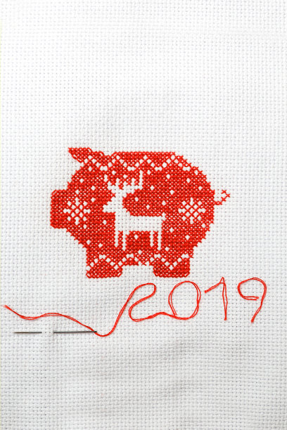 白色帆布上用红线绣着新年装饰品的猪。图片下载
