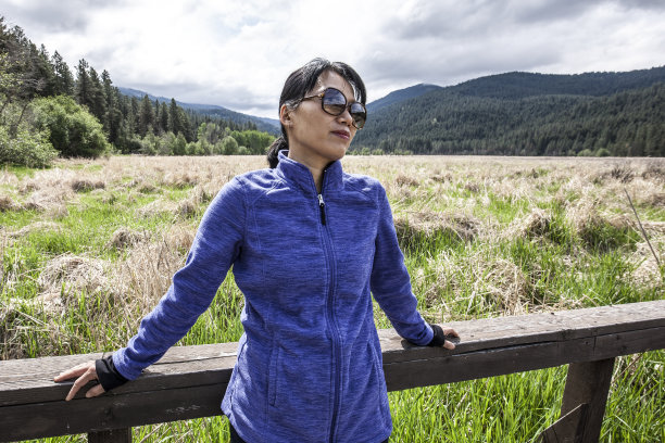 亚洲妇女靠在栏杆上。图片下载