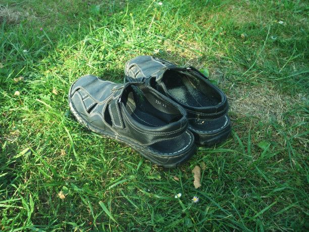 鲜艳的绿色和健康的草坪接近和男人意大利凉鞋图片下载