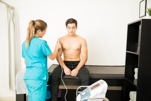 接受理疗师肩部电超声按摩的运动员图片下载