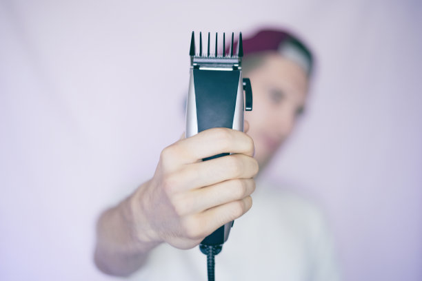 年轻男性潮人手持剃须机孤立图片下载