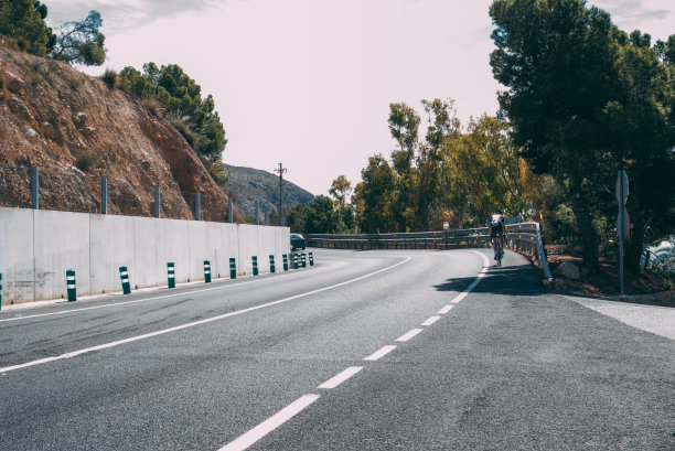 在柏油路上骑自行车的人图片下载