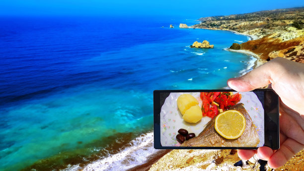 在阿佛洛狄忒的出生地附近，一个充满活力的蓝色翡翠海的图片，人类的手和智能手机显示着海鲜图片下载