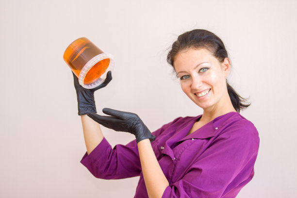 糖膏或蜡蜂蜜程序脱毛在黑手套美容师在水疗沙龙-脱毛和美容概念图片下载