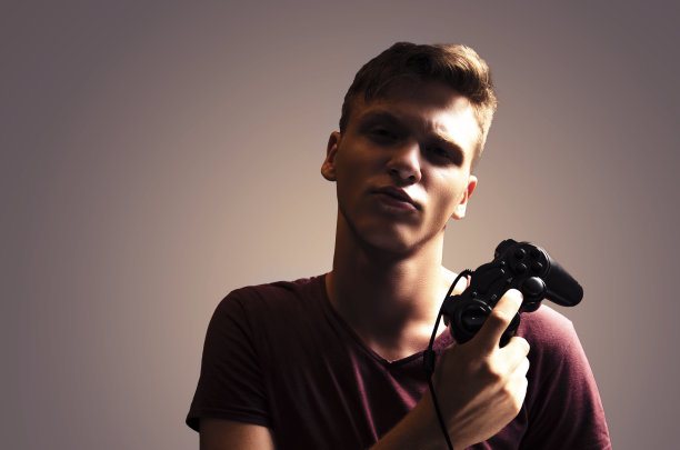 戏剧性的肖像英俊的少年与游戏控制器图片下载