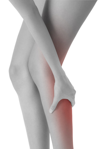 女人抱着她美丽健康的长腿按摩胫骨和小腿疼痛的区域，黑色和白色突出的红色，孤立在白色背景。图片下载