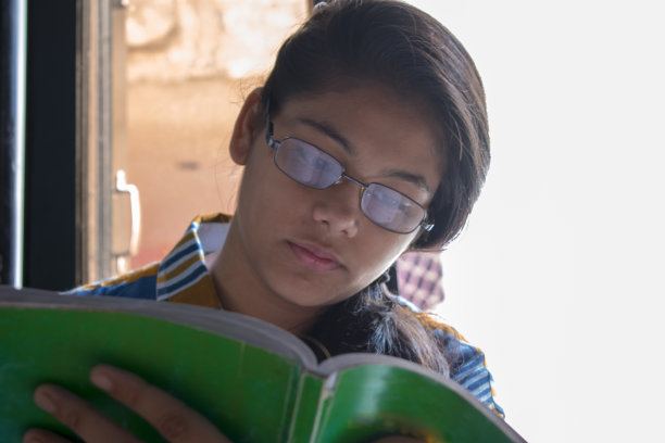 戴着眼镜看书的女孩的肖像图片下载