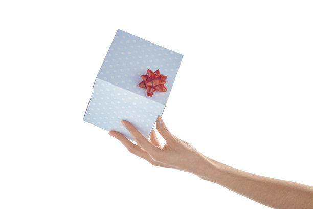 女人手指尖拿着带斑点的蓝色礼品盒图片下载