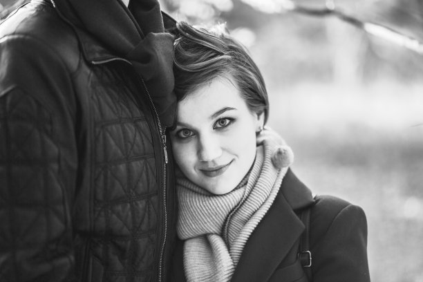 年轻美丽的微笑女人靠在男人的肖像在休闲温暖的衣服拥抱拥抱走在秋天城市公园户外。爱情关系家庭人的观念。黑白照片。图片下载