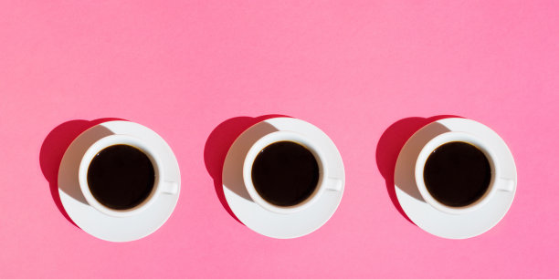 咖啡馆酒吧的长横幅。白色咖啡杯与碟在霓虹灯紫红色背景。前视图。早餐能量咖啡因上瘾概念。时尚简约。强烈的阳光,80年代图片下载