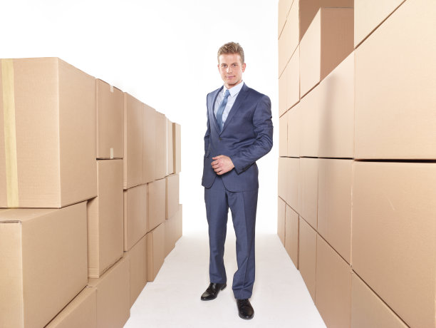 商人站在一堆箱子旁边图片下载