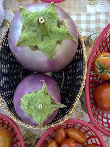 用手机拍下了农贸市场摊贩桌上篮子里的蔬菜的照片图片下载