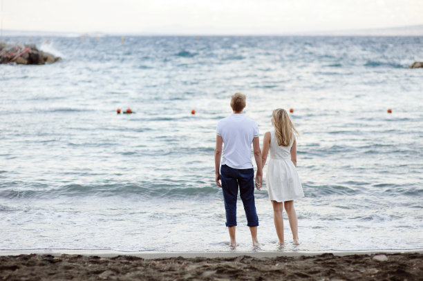 一对相爱的年轻夫妇，手牵着手，在索伦托的大海背景下图片下载