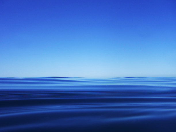 湛蓝的天空下湛蓝的海面。极简主义。图片下载