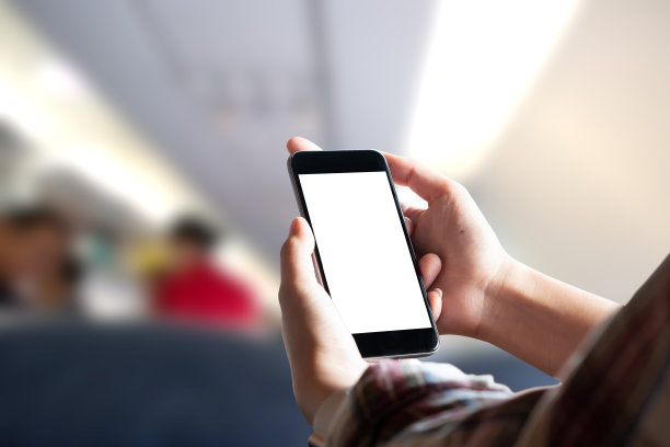 飞机乘客在飞机上使用智能手机。商人在飞机上触摸黑屏手机。用于图形显示蒙太奇。图片下载