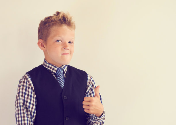 微笑的小男生在白色的黑板旁竖起拇指图片下载