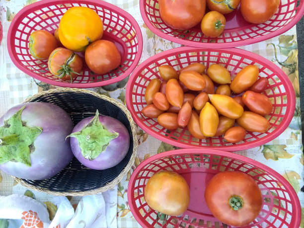 用手机拍下了农贸市场摊贩桌上篮子里的蔬菜的照片图片下载
