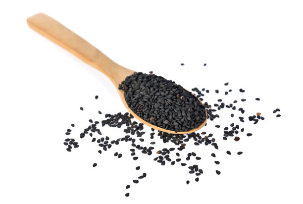 俯视图的汤匙芝麻在白色的背景素材图片