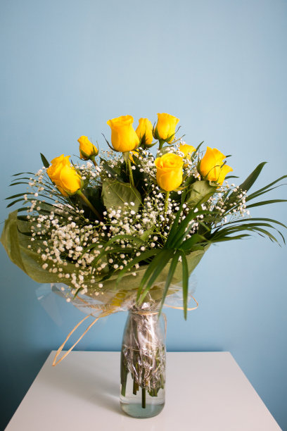 一束黄色玫瑰，表面光滑，白色，背景为蓝色图片下载