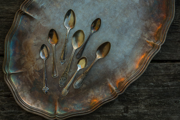 古老的小勺子在一个古老的银盘，托盘。复古餐具、厨房用具为概念，理念上以木质为背景。图片下载