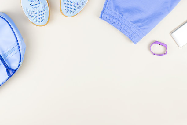 中性背景下的女性运动服、运动鞋、耳机和健身追踪器。运动时尚的概念。平躺图片下载