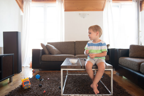一个白人小男孩坐在桌子旁看电视图片下载