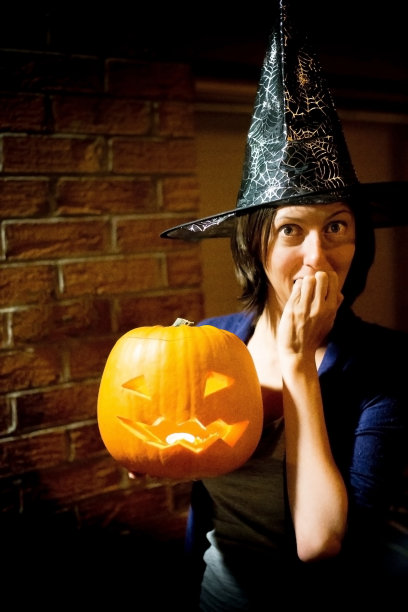 一个穿着万圣节服装拿着南瓜南瓜灯的女孩图片下载