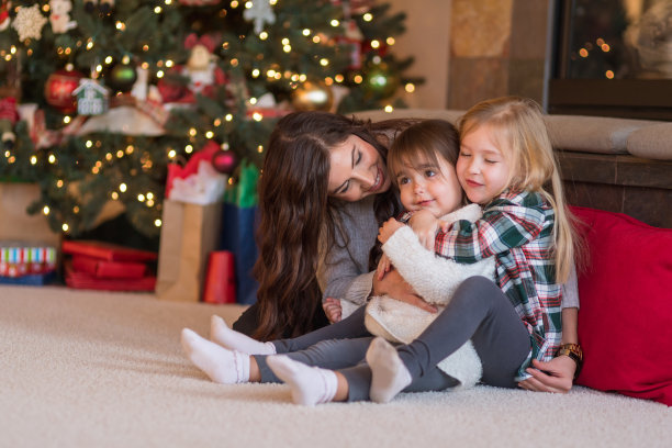 两姐妹在圣诞树前拥抱图片下载