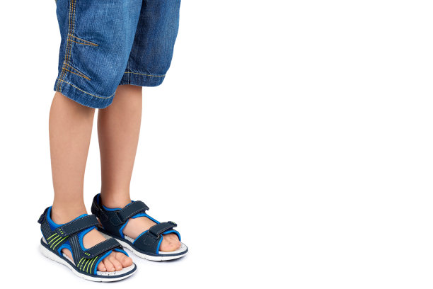 儿童皮凉鞋腿孤立在一个白色背景，复制空间模板图片下载