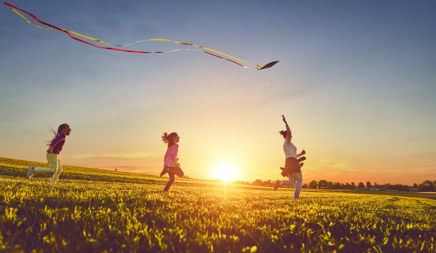 母亲和两个女儿在草地上玩耍图片下载