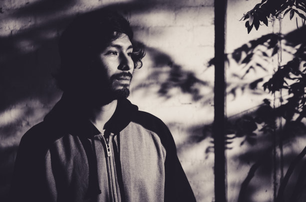 年轻男子的肖像留着胡子，穿着衬衫，有树的影子图片下载