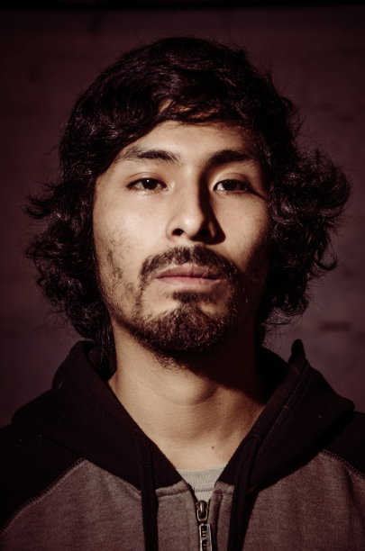 年轻男子的肖像留着胡子，穿着衬衫，有树的影子图片下载