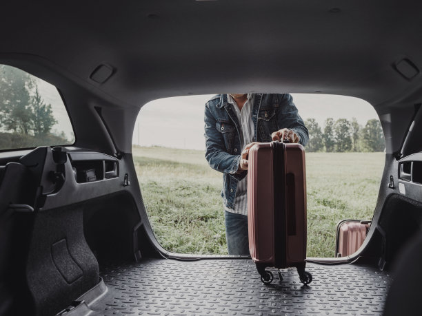 一个男人在他的车里打包他的行李箱准备公路旅行图片下载