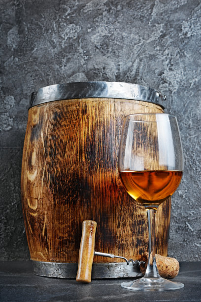 品酒用的白葡萄酒酒杯和带开瓶器的木桶图片下载
