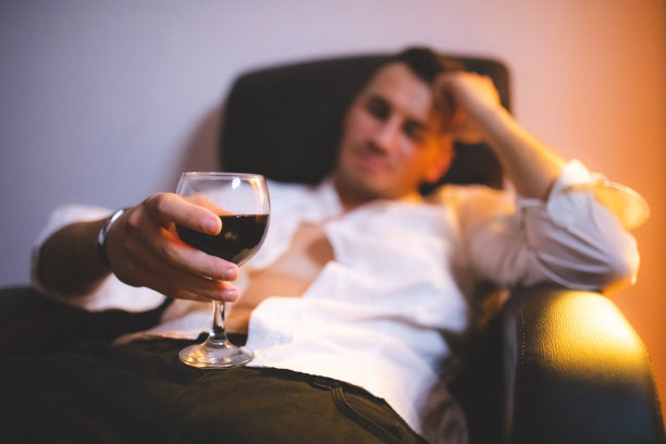 拿着酒坐在椅子上的男人图片下载