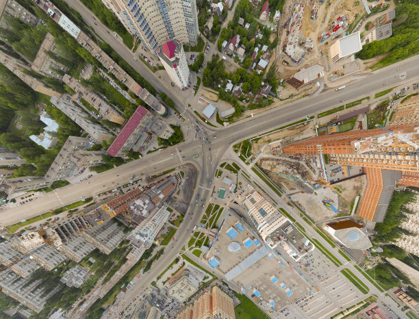 鸟瞰图的广场在城市与环岛交通，街道和建筑与绿树在地球的部分全景照片图片下载